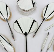 An Art Deco silver and enamel part dressing table set comprising a powder pot, two hair brushes, two