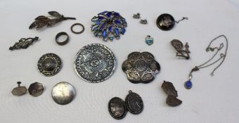 A Mexican silver brooch of circular form with a central mask, and a repeating pattern, together with
