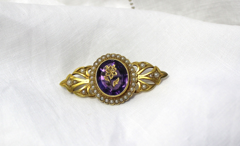 A yellow metal bar brooch with a central oval amethyst inset with a floral design surrounded by seed - Image 2 of 4