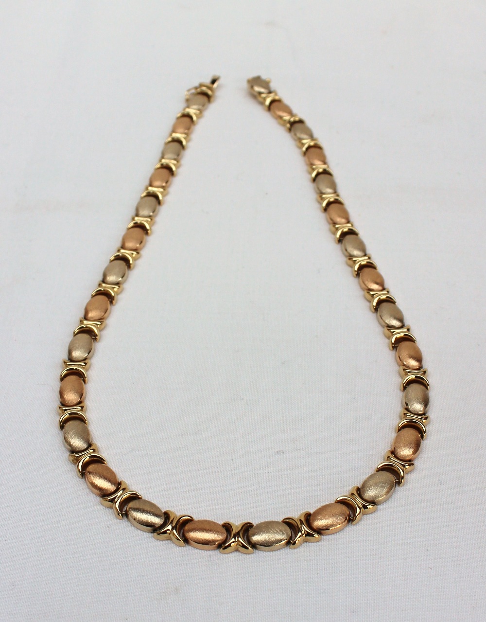 An 18ct yellow gold textured oval and C scroll link necklace, approximately 27 grams