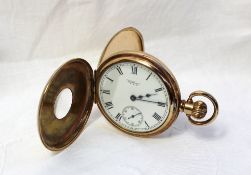 A yellow metal keyless wound half hunter pocket watch with an enamel dial, Roman numerals and