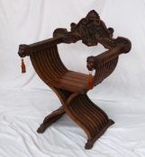 A 19th century walnut Savonarola Chair, the removable back carved with winged griffins, the arm