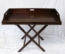 A George III mahogany butlers tray with three inset handles 99cm wide x 49cm deep on a folding base