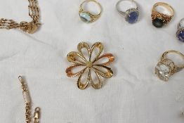 An 18ct yellow gold brooch in the form of a daisy with textured petals approximately 4 grams