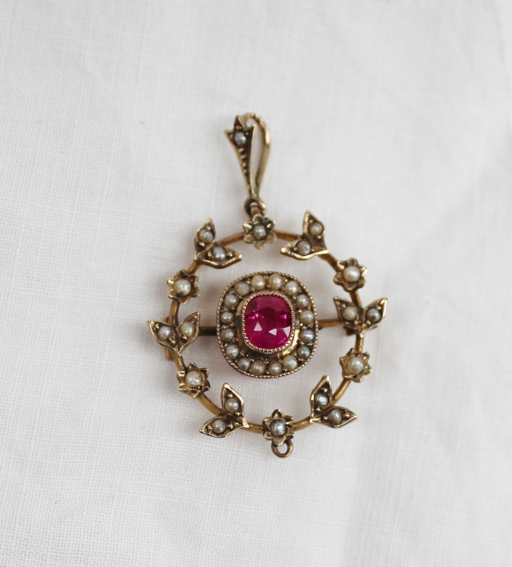 A ruby and seed pearl pendant, the central ruby surrounded by a ring of seed pearls, and pearls