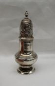 A George II silver sugar caster, the pierced domed cover with a turned finial, above a baluster body