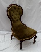 A Victorian mahogany framed spoon back nursing chair with a button back and pad seat on scrolling