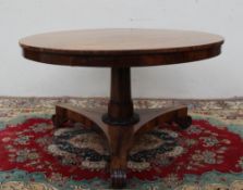 An early 19th century Rosewood supper table, the circular top with a snap action on a tapering