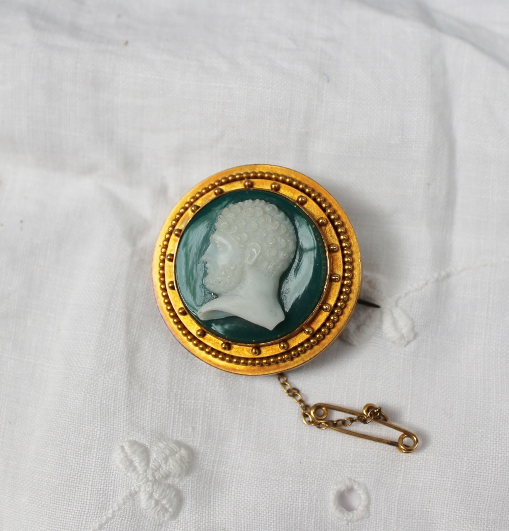 An Agate Cameo brooch with the head of a gentleman in profile to a yellow metal bead decorated