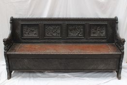 A 19th century oak bench, the back with four carved panels decorated with figural scenes, the arms