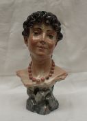 A continental pottery bust of a maiden with a bead necklace, signed Fed Alle Mollica, 29cm high