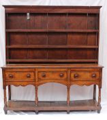An 18th century South Wales oak dresser, the rack with a moulded cornice above three shelves with