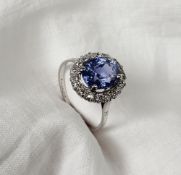 A sapphire and diamond dress ring, the central oval faceted sapphire surrounded by 18 old cut