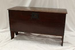 An 18th century oak coffer, the planked top above a line decorated front on slab sides, 97cm wide
