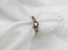 A solitaire diamond ring of cushion shape and old cut to white metal setting and yellow metal