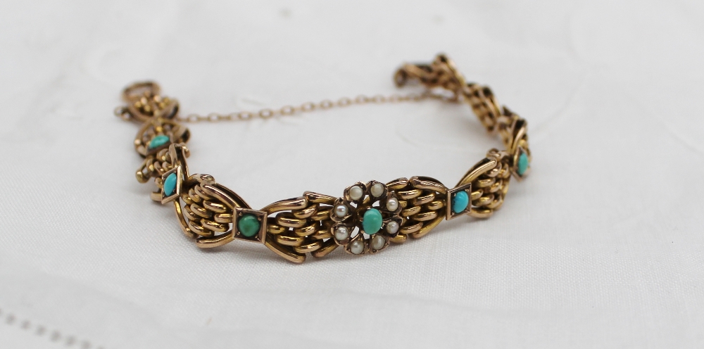 A yellow metal bracelet of pointed oval bar form set to the centre with a turquoise cabachon