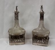 A pair of German silver mounted clear glass bottle decanters, possibly by Neresheimer & Co, Hanau,