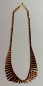 A 9ct yellow gold fringe necklace of wave form with separate cylindrical links, approximately 36