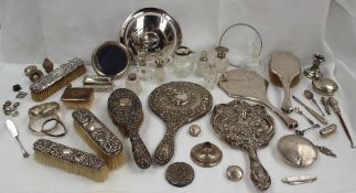 A large collection of silver items including hinged bangles, dressing table pots, photograph