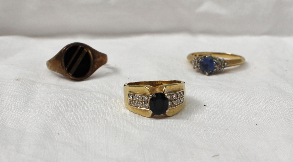 An 18ct yellow gold dress ring set with a central oval sapphire, the shoulders set with sixteen
