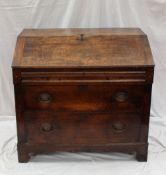 A late 18th / early 19th century oak bureau, the sloping fall enclosing a fitted interior of