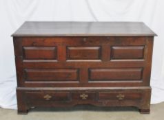 An 18th century oak coffer, the rectangular top above a five panelled front above three drawers on