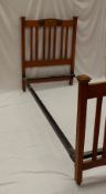 An oak Arts and Crafts single bed decorated to the head and foot board with a central green enamel