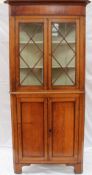 A 19th century oak standing corner cupboard, the moulded cornice above a mahogany frieze, a pair