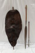 An African hide shield of oval form, mounted onto a wooden stake, possibly crocodile, overall length