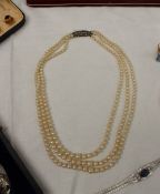 A three strand pearl necklace with graduated pearls to a marcasite clasp together with another pearl