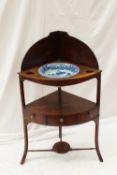 A George III mahogany corner wash stand with a shaped back above three recesses and central