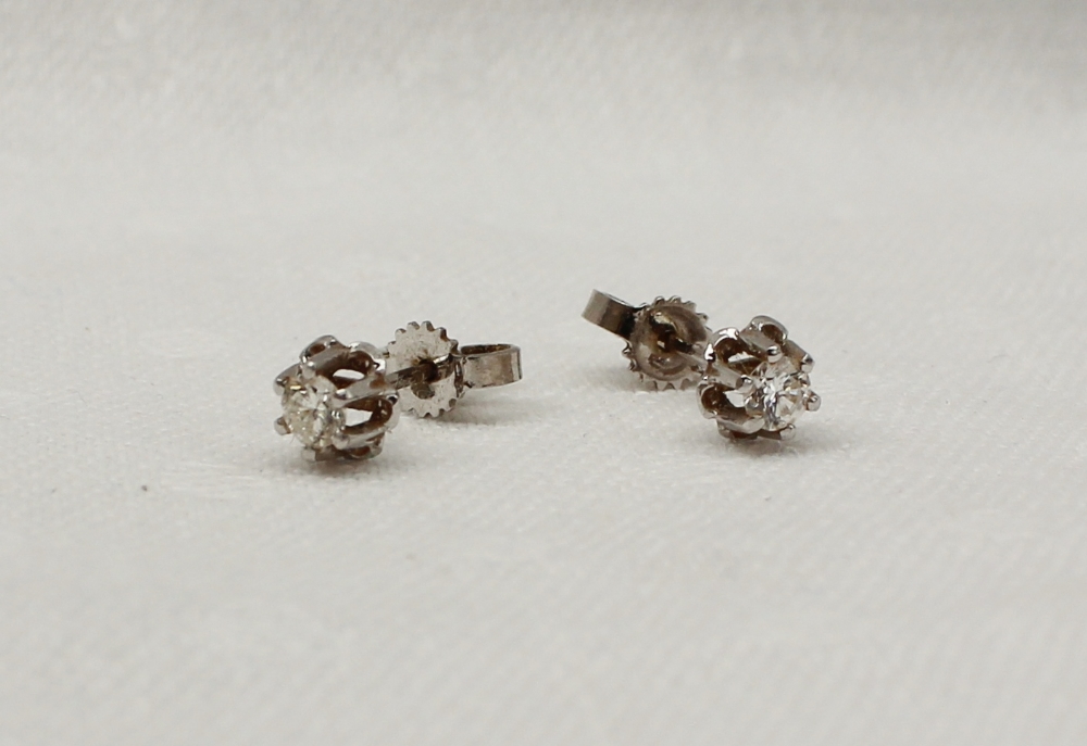 A pair of diamond stud earrings, the round brilliant cut stones to an 18ct white gold claw setting
