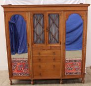 A Waring and Gillow oak bedroom suite comprising a triple wardrobe, the central section with a