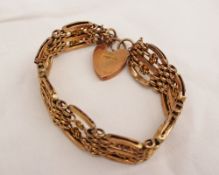 A 9ct yellow gold gate bracelet with C scrolls and knots to a padlock clasp, approx 24 grams