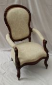 A Victorian walnut framed nursing chair, the shaped back above a pad upholstered seat and arms on