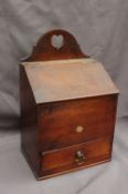 A 19th century oak candle box, with a heart shaped camel back, above a sloping top and base