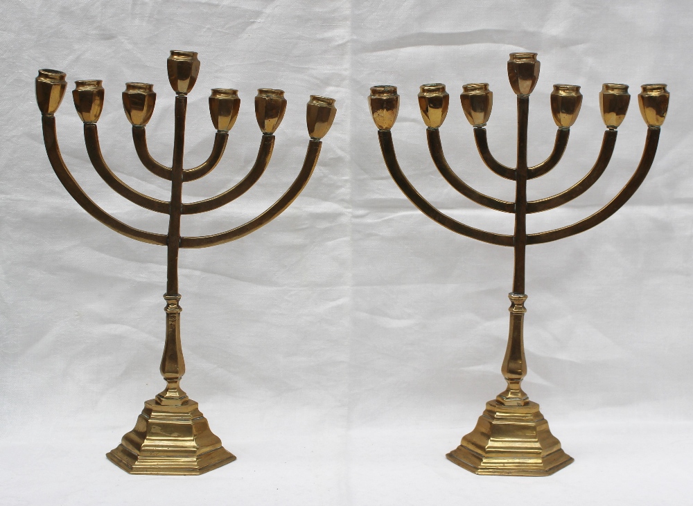 A pair of seven branch menorah with hexagonal columns on stepped bases, 37cm high