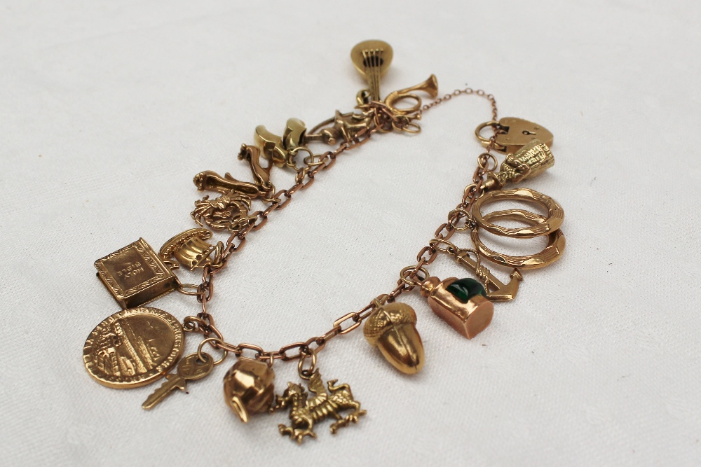 A 9ct yellow gold charm bracelet set with numerous charms including a Welsh lady, earrings,