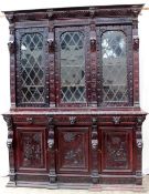 A 19th century continental carved oak bookcase, the cornice carved with lions heads and leaves above