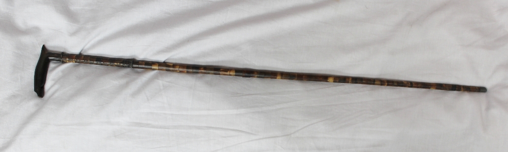 A walking stick with a horn handle fashioned into a whistle, the shaft comprising sections of