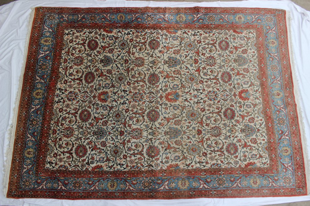 A Persian carpet, with a cream ground and interwoven flowers and leaves, to multiple borders with