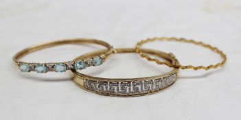 A yellow metal bangle set with numerous diamonds in a geometric pattern totalling approximately 0.25