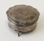 A George V silver dressing table jewellery box of shaped circular form on cabriole legs and pad