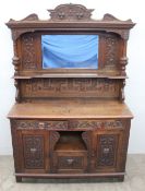 A late 19th century mirrorback sideboard, the cornice carved with fruit, scrolls and leaves above