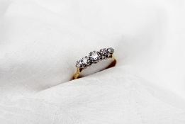 A five stone diamond ring set with round brilliant cut diamonds of graduated sizes to a white