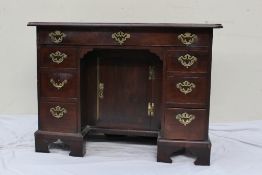 A George III and later mahogany kneehole desk, the rectangular top above a long frieze drawer, two