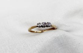 A three stone diamond ring set with three old cut diamonds to a white metal setting and yellow metal