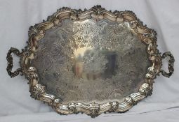 A large twin handled electroplated on copper tray, with a scrolling and leaf decorated edge, the