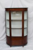 An Edwardian mahogany display cabinet, the moulded cornice above a single glazed door and sides, the