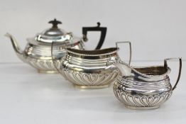 An Edward VII silver three piece teaset, with scrolling decoration and a wave rim, Birmingham, 1901,